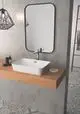 Waschtisch mit rechteckigem, weißen Becken auf einer Holzplatte. Chrom-Armatur von Ideal Standard montiert, daneben sind Pflegeprodukte und ein Seifenstück auf einem kleinen Teller.